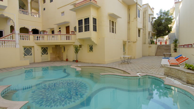 Side view of the swimming pool with loungers on the side - Mandawa Haveli, Jaipur