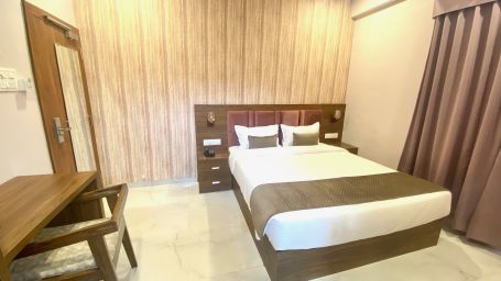 Roo with plush bed and study area at Hotel Mumbai House, Indore