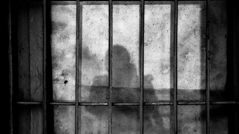 A closeup shot of a jail with the person who is taking the picture's shadow showing up inside