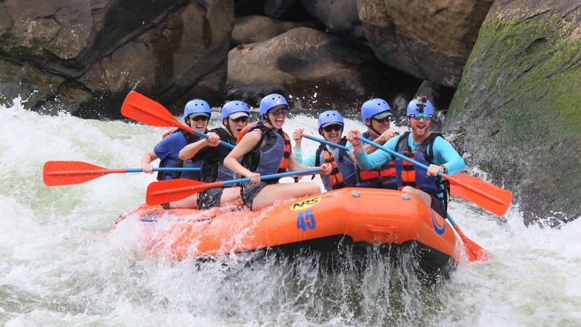 a group of people rafting in the waters of Rishikesh