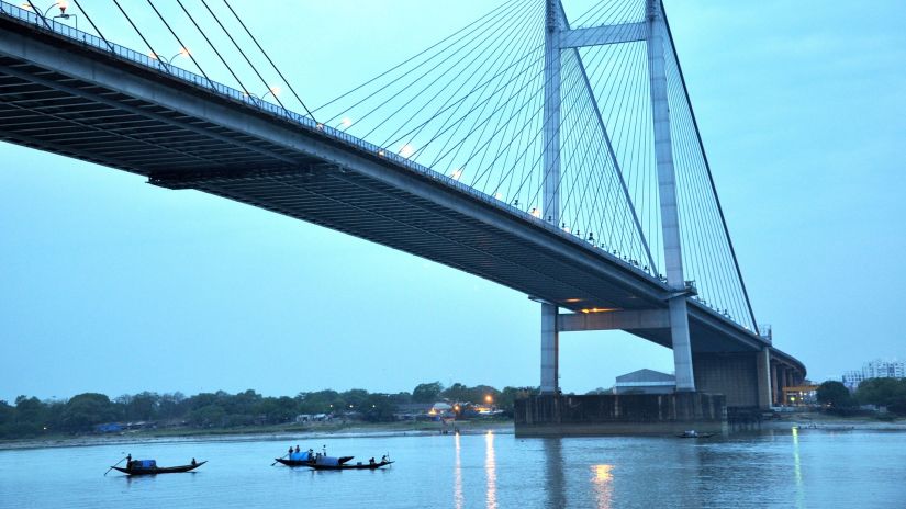 view of howrah bridge and boats cruising beneath the bridge on the river 1