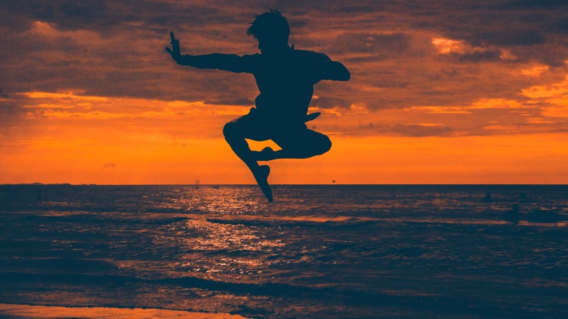 silhouette of a person jumping on a beach