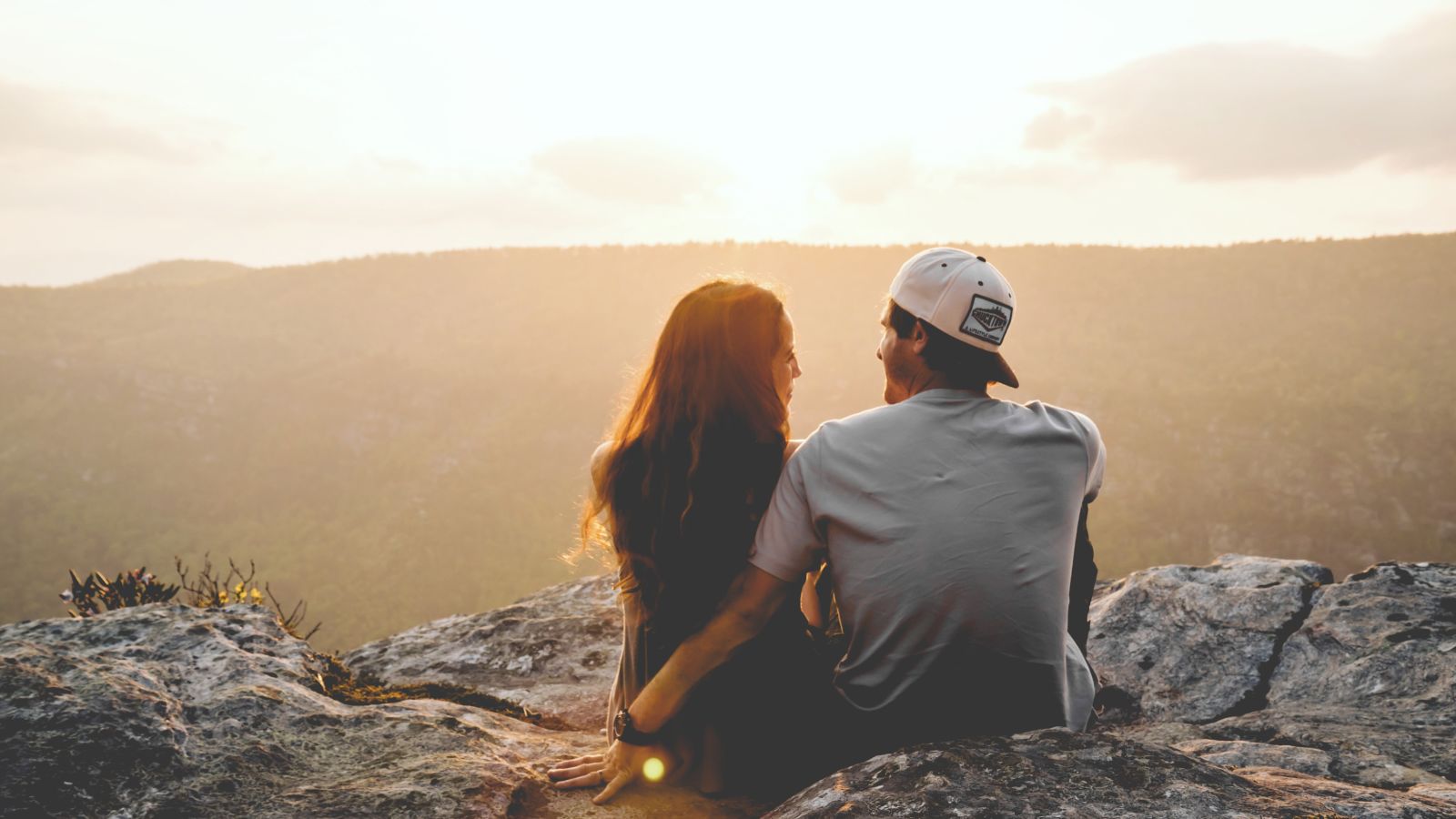 Couple on a hill watching the sunset