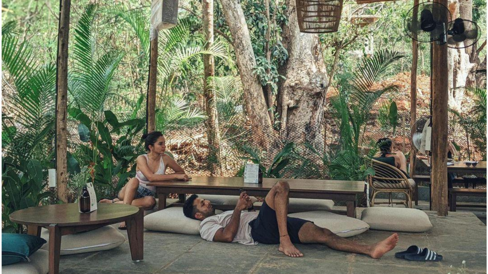 a couple relaxing under a thatched gazebo at villa in palms