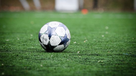 a lonely football on grass pitch