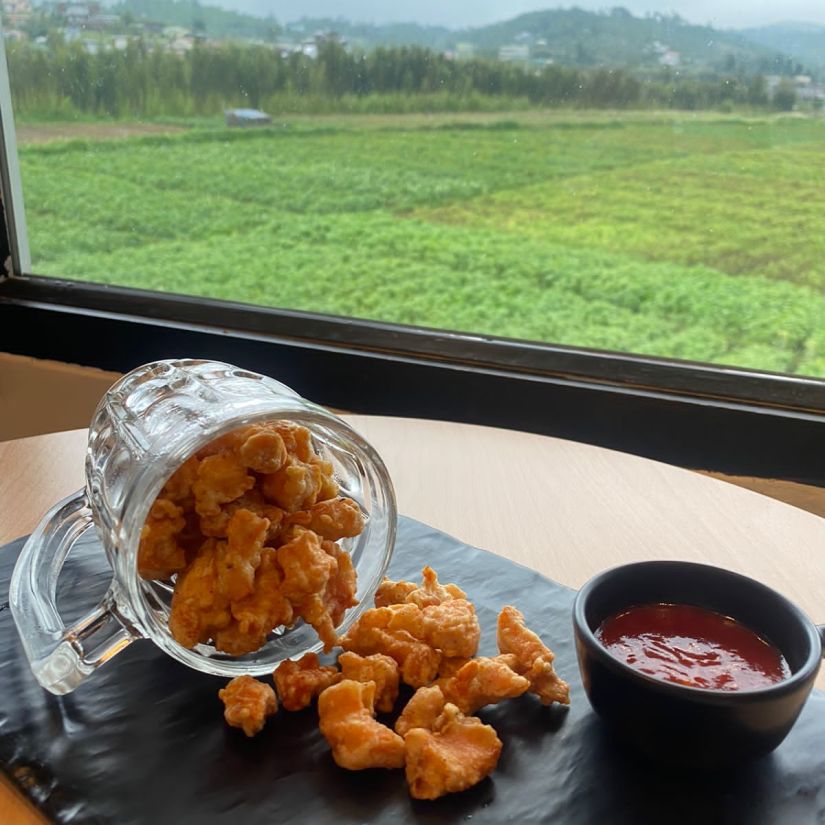 An enticing view of fritters spilling over to the table next to a ketchup dip