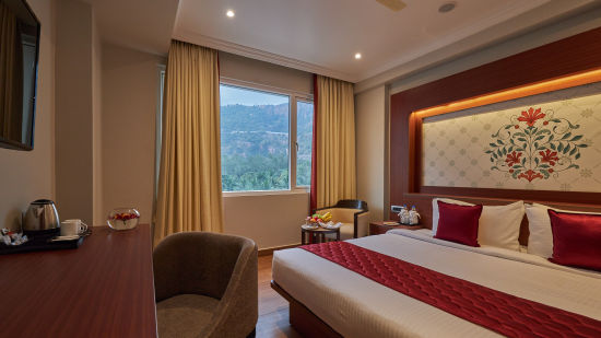 king size bed offered at the deluxe room along with a work station - Golden Tulip, Tirupati