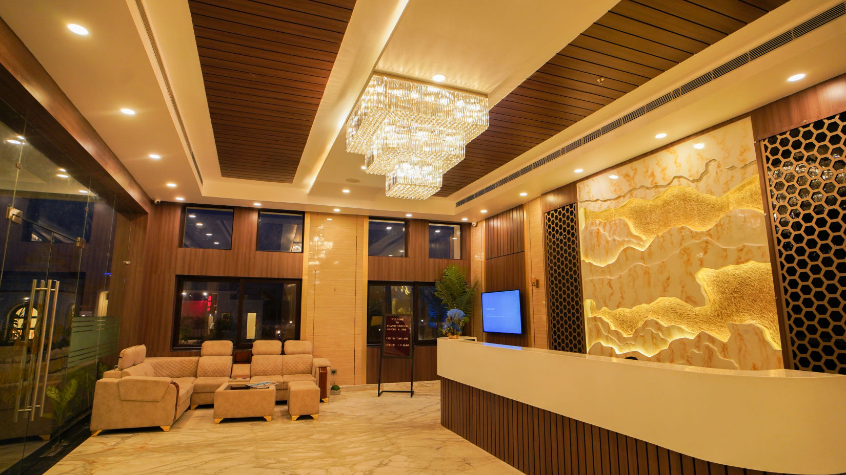 overview of the lobby with the reception desk and a fancy chandelier hung on the roof - Shanti Seaview Resort & Spa