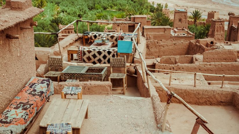 a mud terrace with seatings and greenery in the background