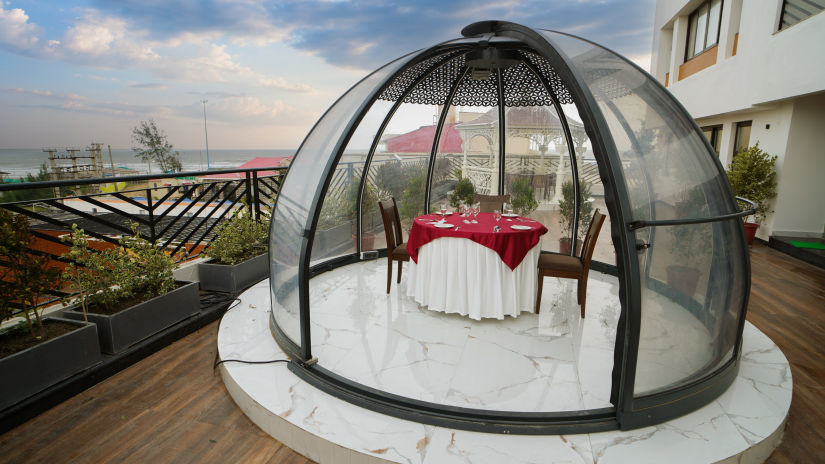 a half bubble kind of architecture with a table for two set inside it on the terrace - Shanti Seaview Resort & Spa - Hotels in Mandarmani Sea Facing