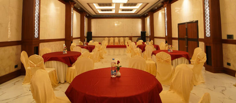 overview of the banquet hall with round table seating arrangement and a chandelier hung above - Shanti Seaview Resort & Spa