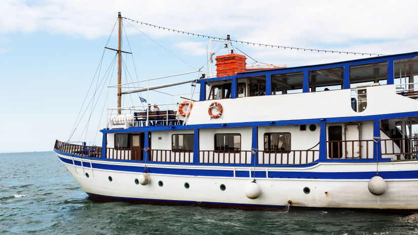 water ferry full of tourists leaving the cost during the day