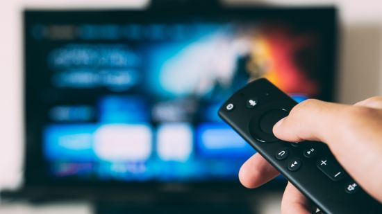 a person holding a remote in front of a television