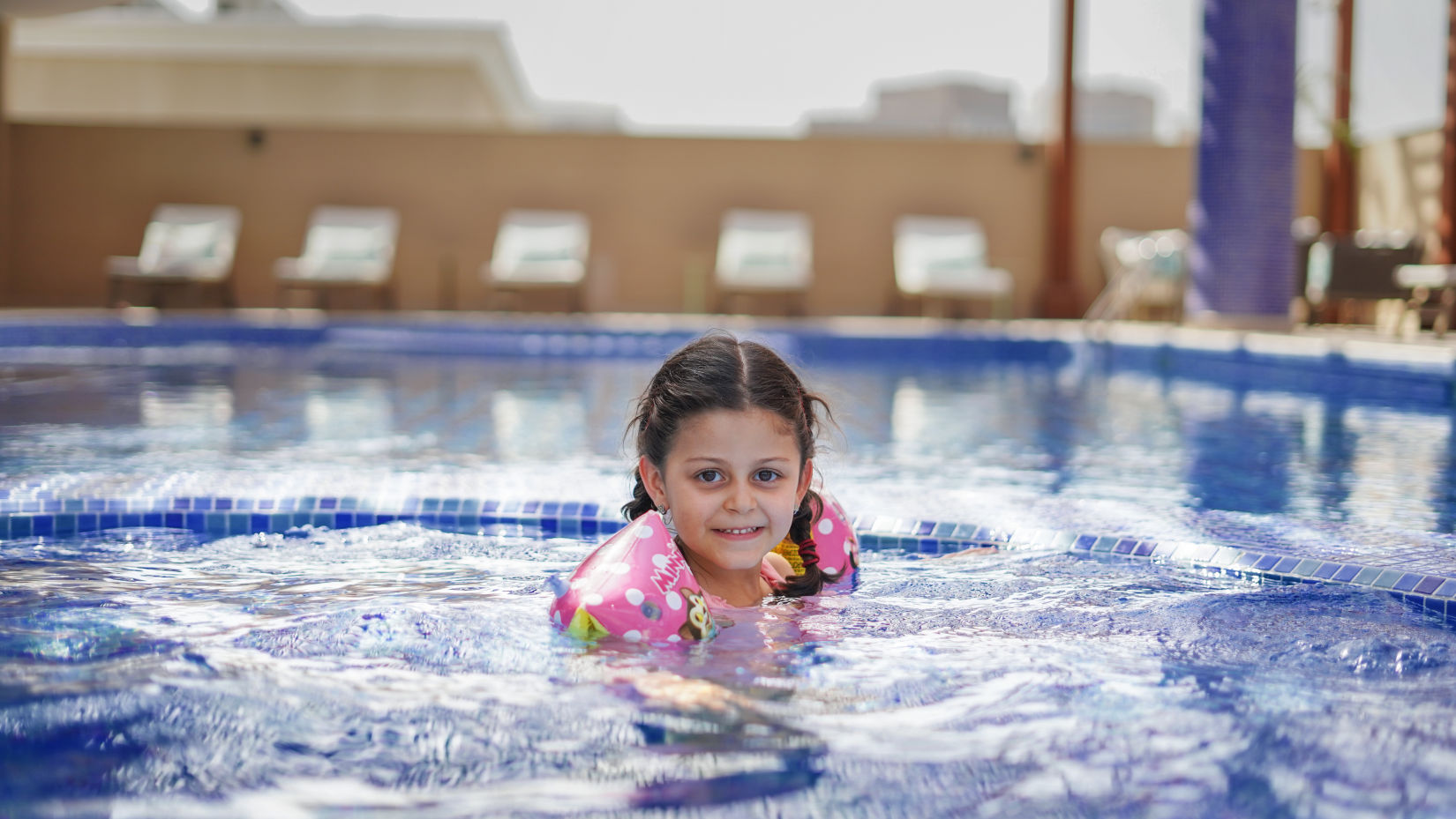 A girl child enjoying swimming inside the Kids Pool - La Maison Hotel, Doha