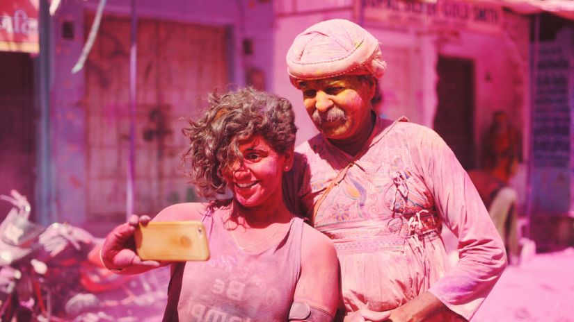 two people taking a photo while celebrating a festival in alwar