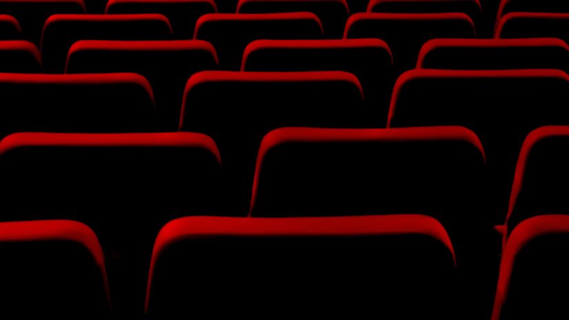 many empty chairs made of the colour red inside a cinema