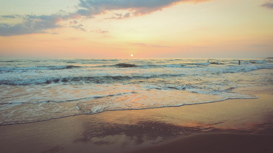 Waves overlapping on the beach with the setting sun in the background