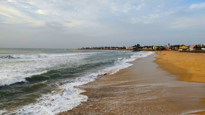 view of a beach with waves overlapping on the sand