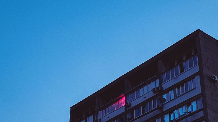 A building's facade with glass windows and blue sky in the background