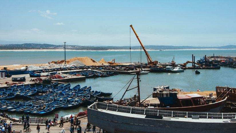 an overview of a port on the ocean with many boats stationary near the port