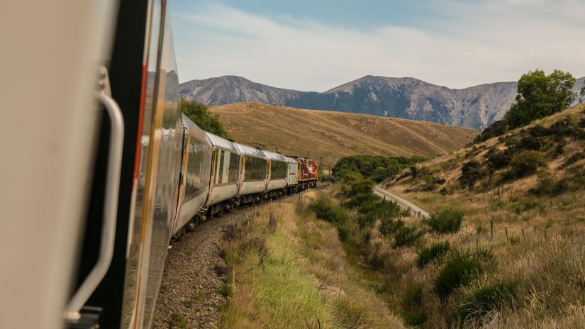 The view of the train disappearing in between the hills taken from inside the train