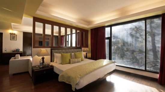 a view of a bed in Suite decked with a bed with yellow duvet at Mastiff Grand, Manali