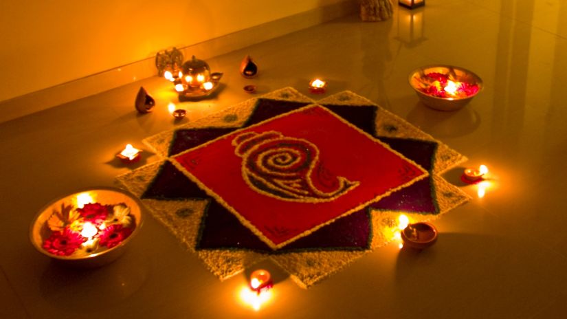 an image of rangoli surrounded by diyas 