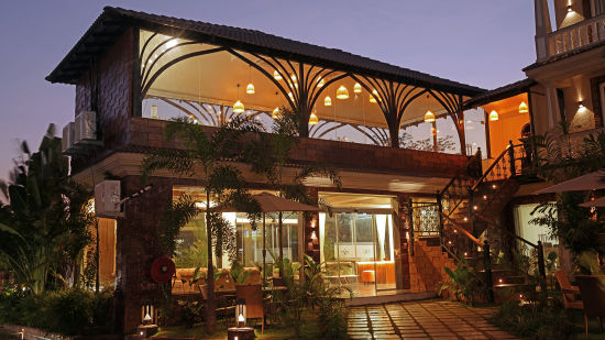 Elegant evening view of a flavour dining area with warm lighting at Grand Continent, Anjuna - A Sarovar Portico Affiliate Hotel 