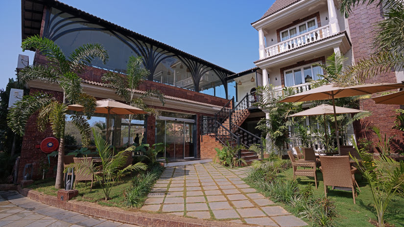 Facade image of the Grand Continent, Anjuna - A Sarovar Portico Affiliate Hotel  with lush green plants around.