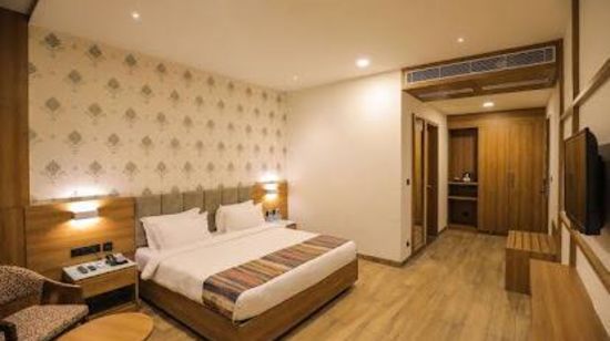 standard room at Comfort Resort, Morbi packed with a bed, television and a myriad of modern amenities