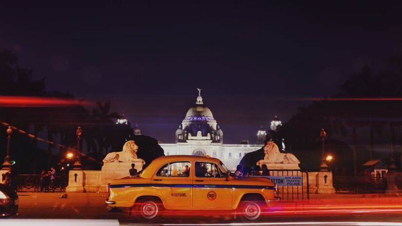 a taxi passing by Victoria Memorial