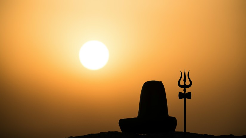 Shiv linga with a trishool against sunset