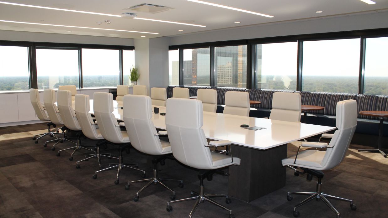 Seats arraged inside the boardroom with a big desk