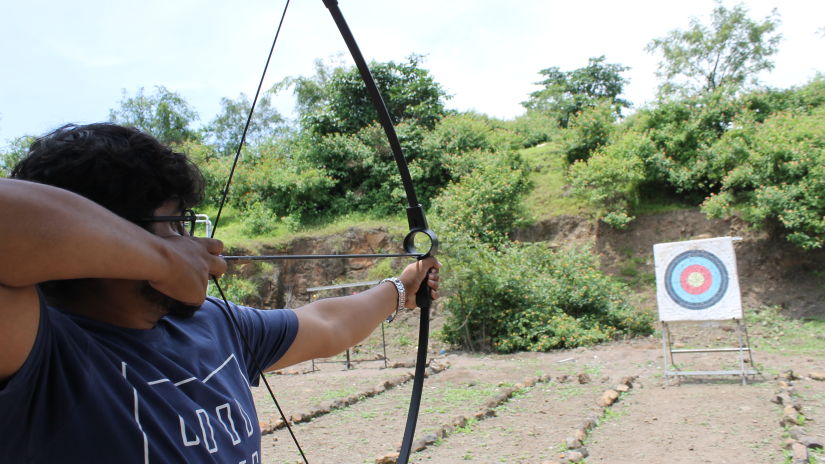 Man shooting at arrow at an archery target board at Fort JadhavGADH - A Gadh Heritage Hotel