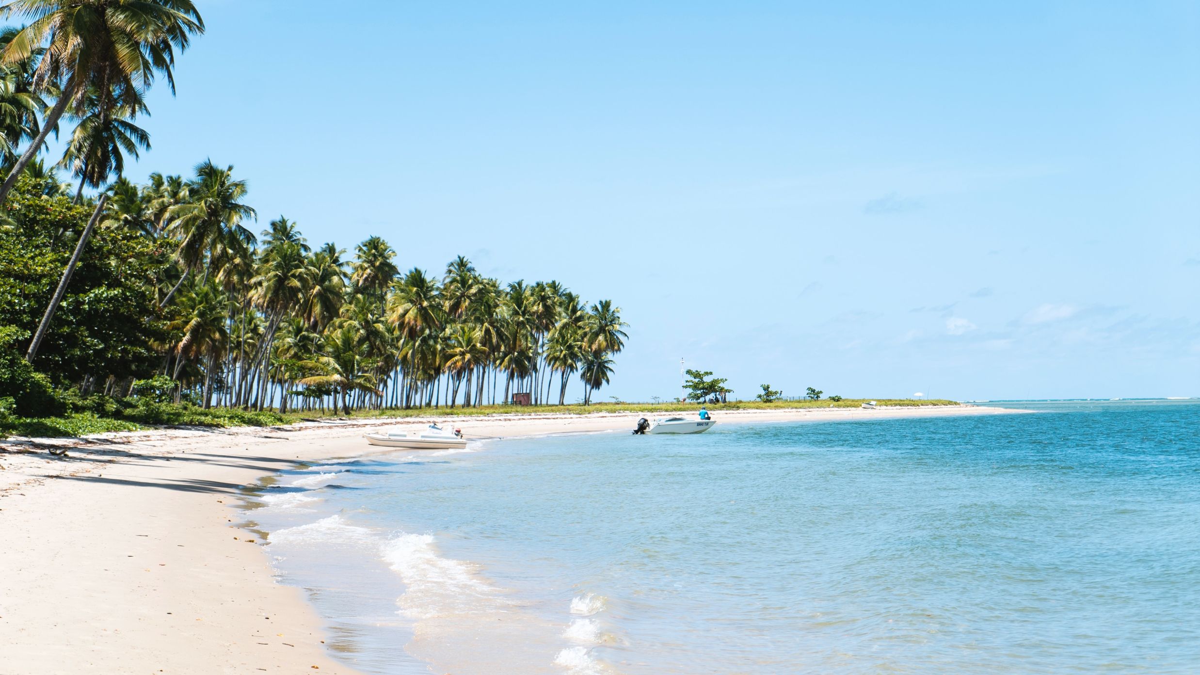 beach with blue waters and small waves on the shore