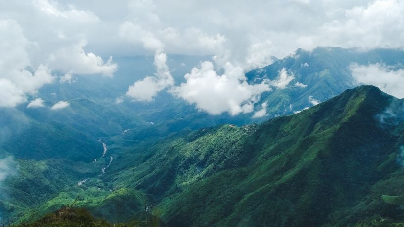 view of the green hills with clouds floating 