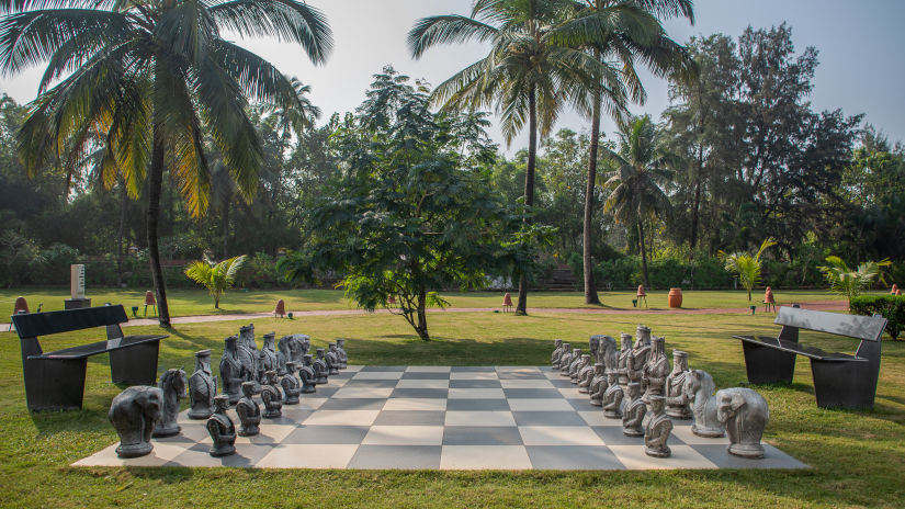 A huge chess board placed on the lawn surrounded by palm trees at Kenilworth, goa best resorts for family