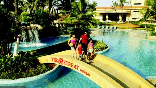 guests walking on the bridge over the Pool at The Retreat Hotel and Convention Centre Madh Island