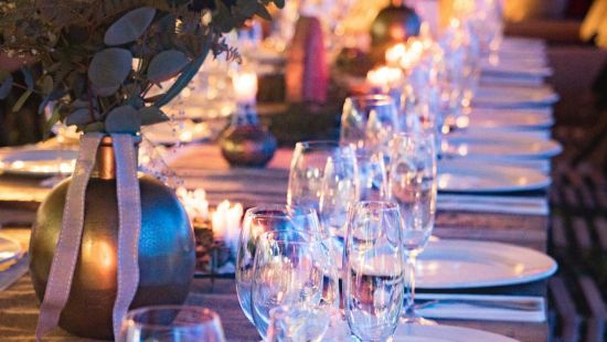 A dining table with plates and glasses neatly lined