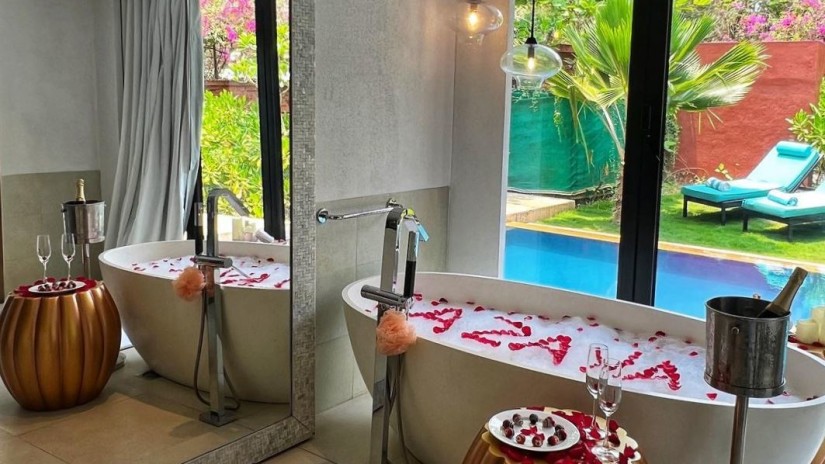 Bathtub filled with a bubble bath and azaya written with rose petals inside the tub - Azaya Beach Resort