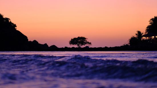 Palolem beach glistens under a colorful sky during dusk - Nightlife in South Goa