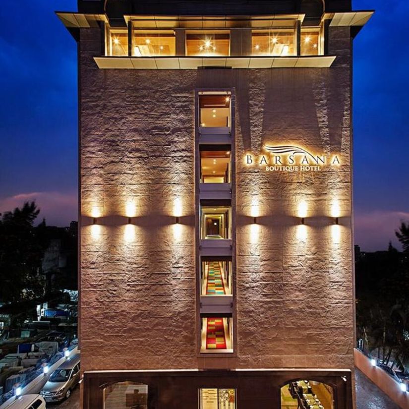a tall hotel building constructed with bright lighting - Barsana Boutique Hotel Kolkata