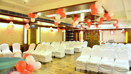 A front view of chairs placed in a banquet hall decorated with ballons | Hotel City Inn, Varanasi