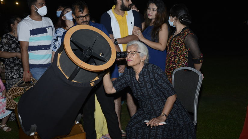 A lady observing space from a telescope at our resort