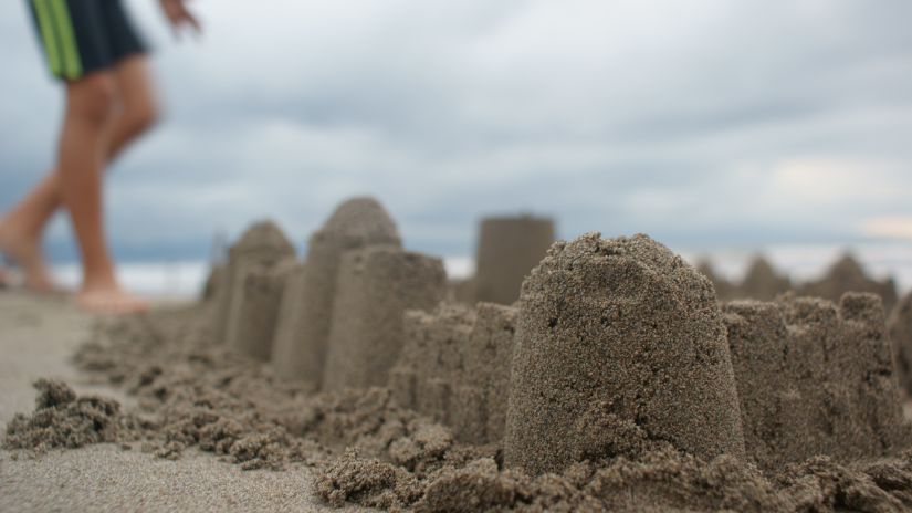 child building a sand castle near the beach