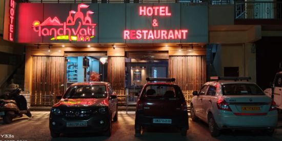 alt-text Facade of Hotel Panchvati Inn with cars parked outside