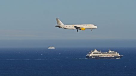 A ship sailing in water and plane flying