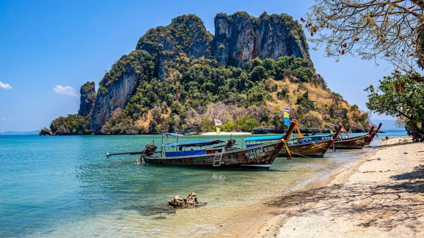 boats on a beach with an island in the background