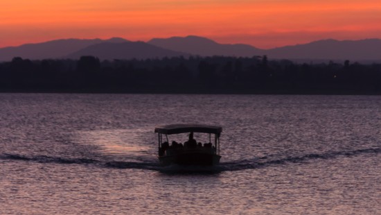 a boat cruising through a river during evening