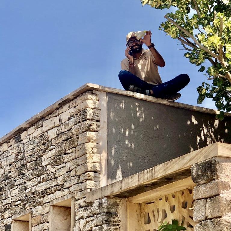 Man sitting on a terrace next to a tree